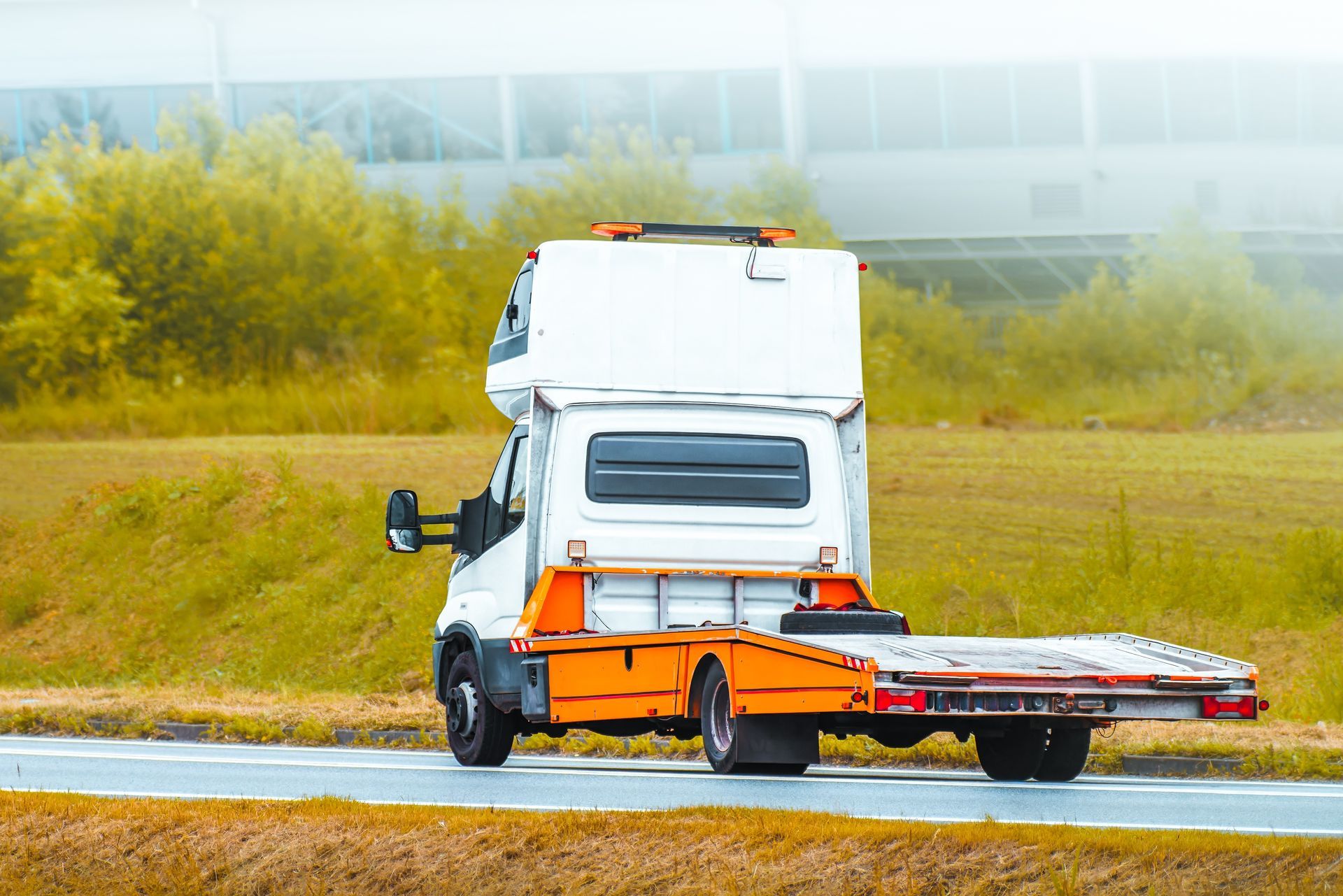 Tow Truck Driving on Road, With a Flatbed — Mission Truck Training in Maroochydore, QLD