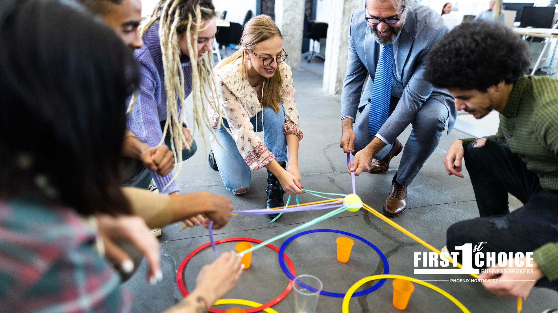 A group of people are playing a game with hula hoops and a ball.