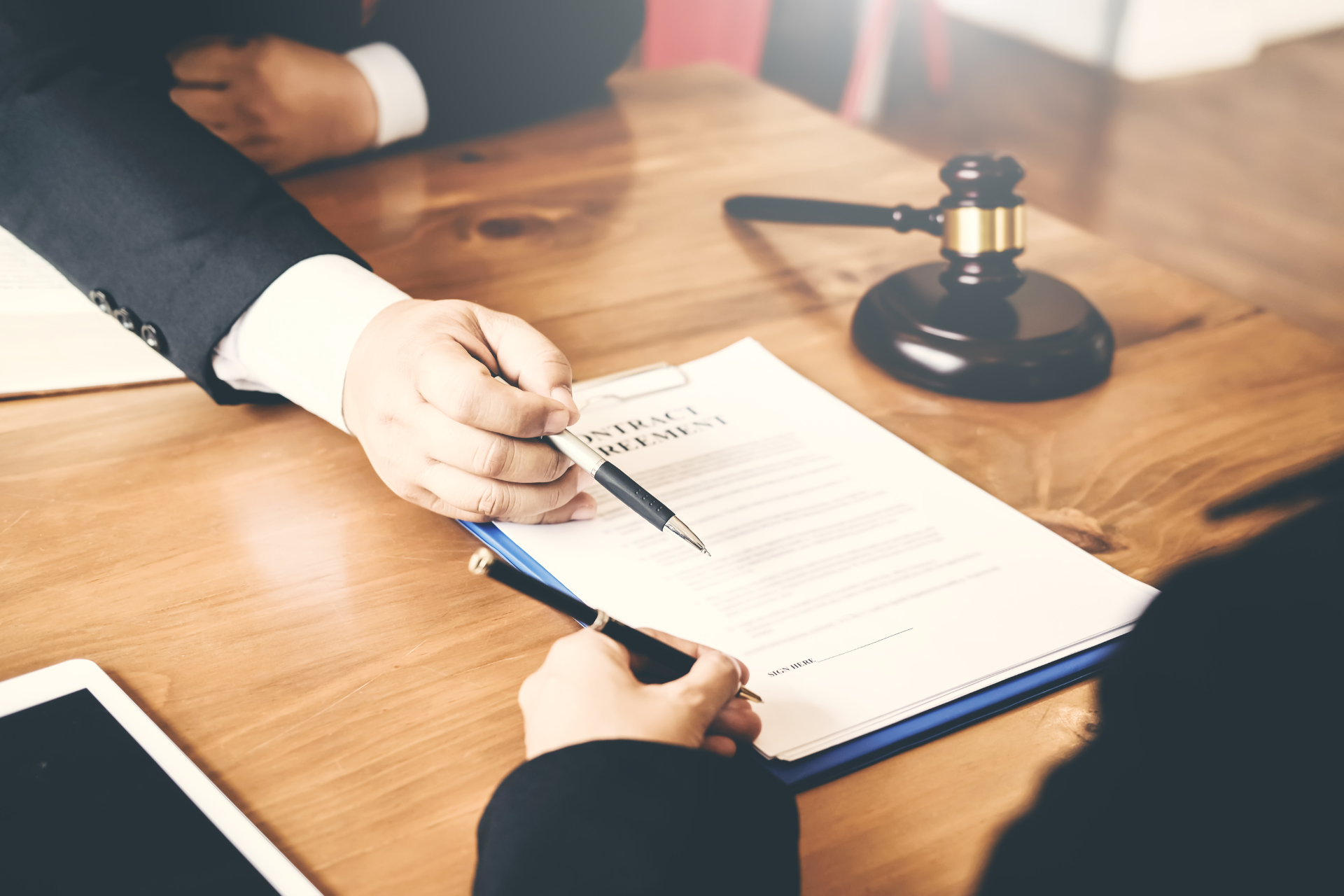A man and a woman are sitting at a table signing a document.