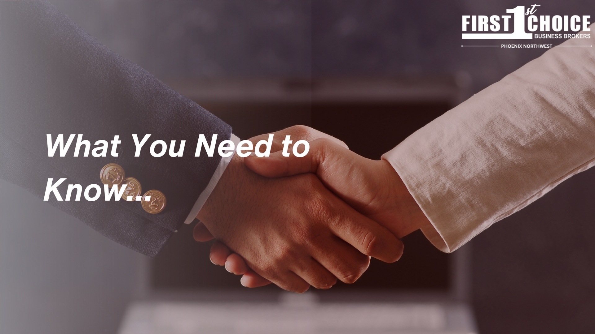 A man and a woman are shaking hands in front of a laptop.