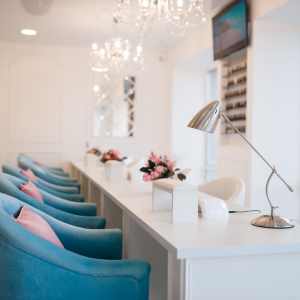 A row of blue chairs are lined up in a salon