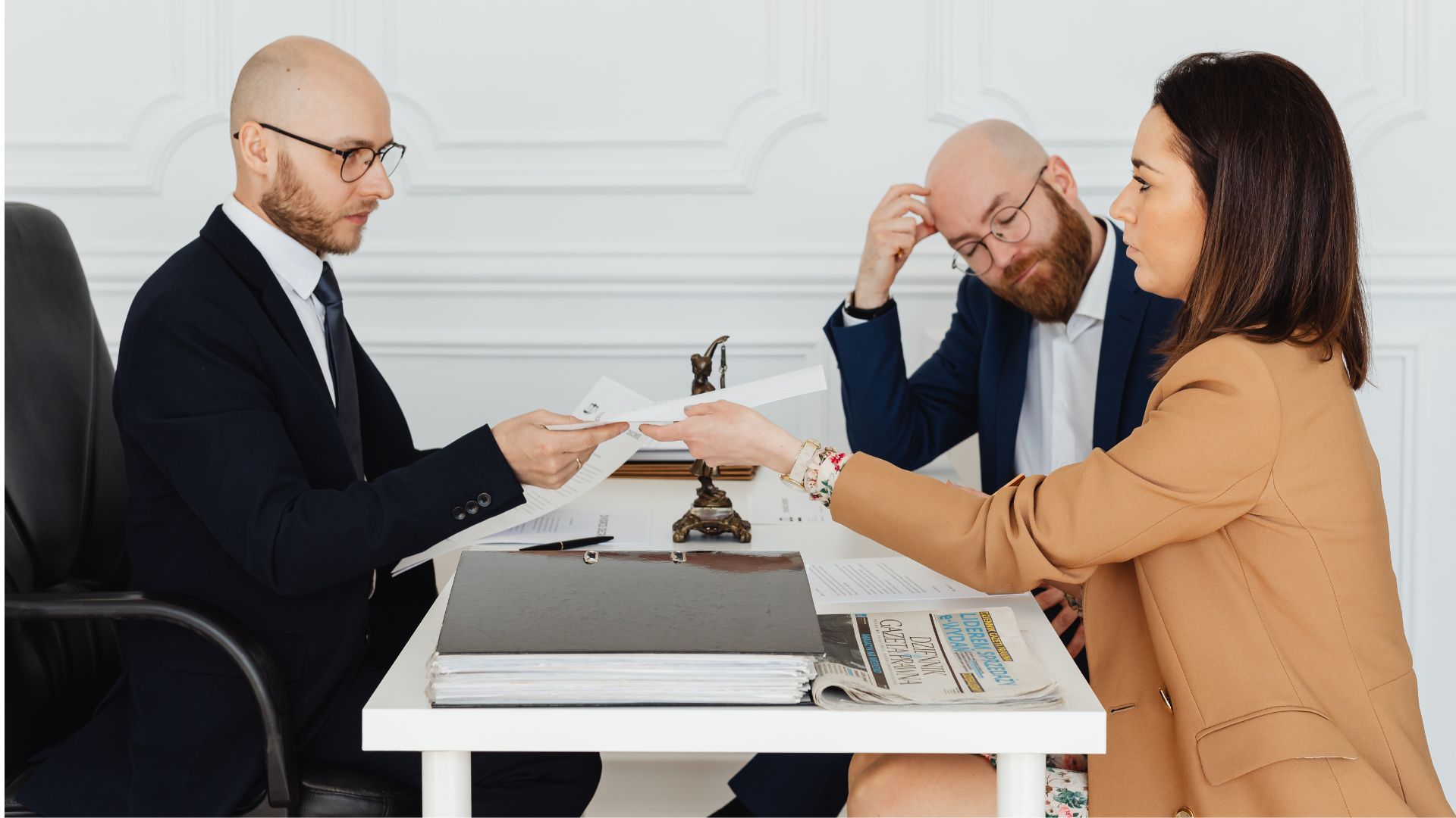 Three business professionals shaking hands outside a glass office building