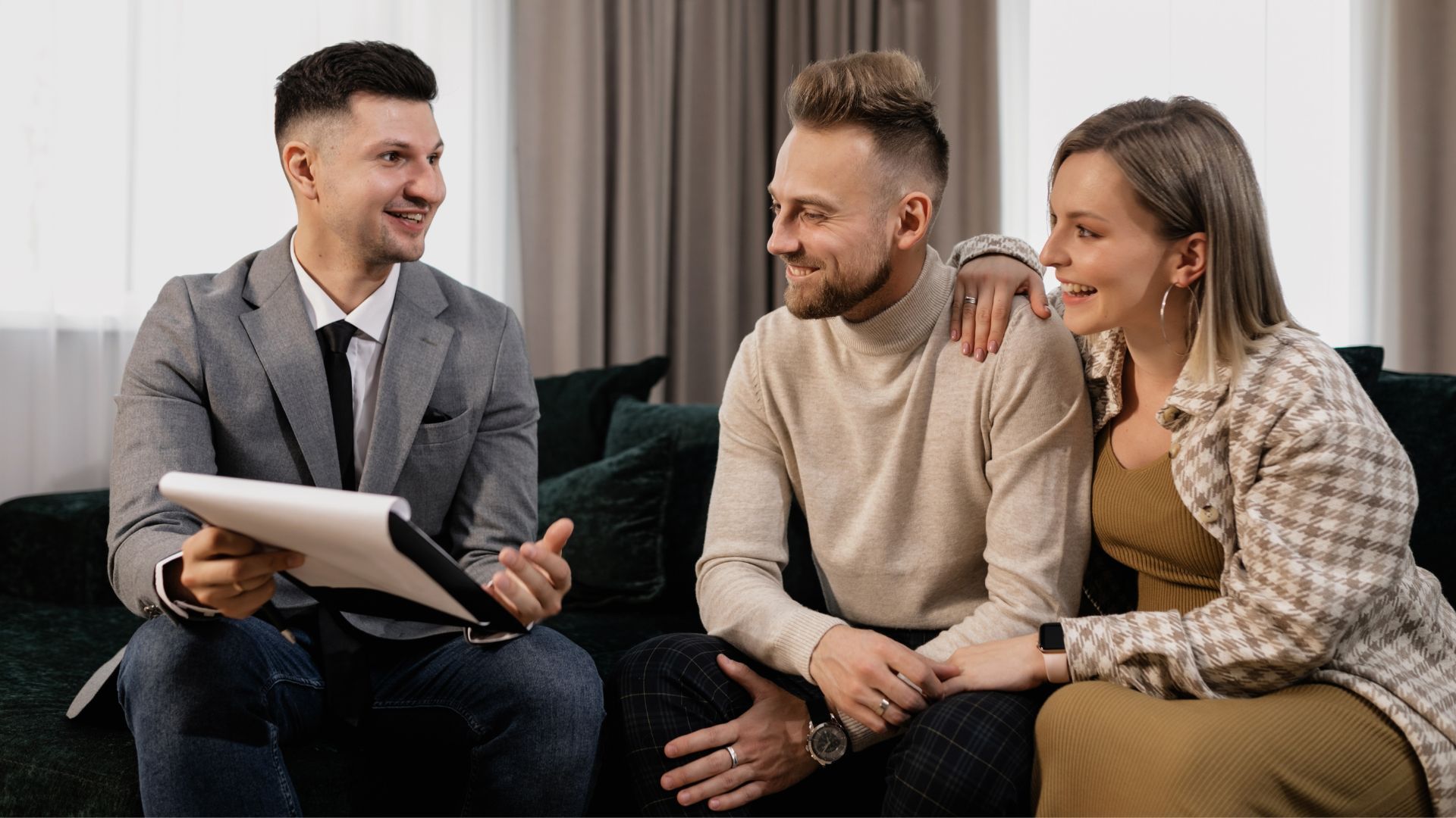 Therapist talking with a smiling couple on a couch in a bright living room