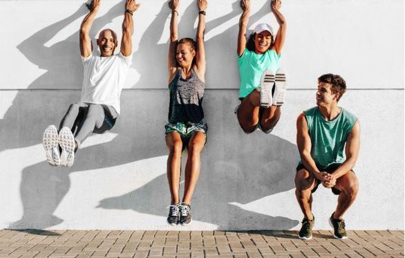 A group of people are doing exercises on a wall.
