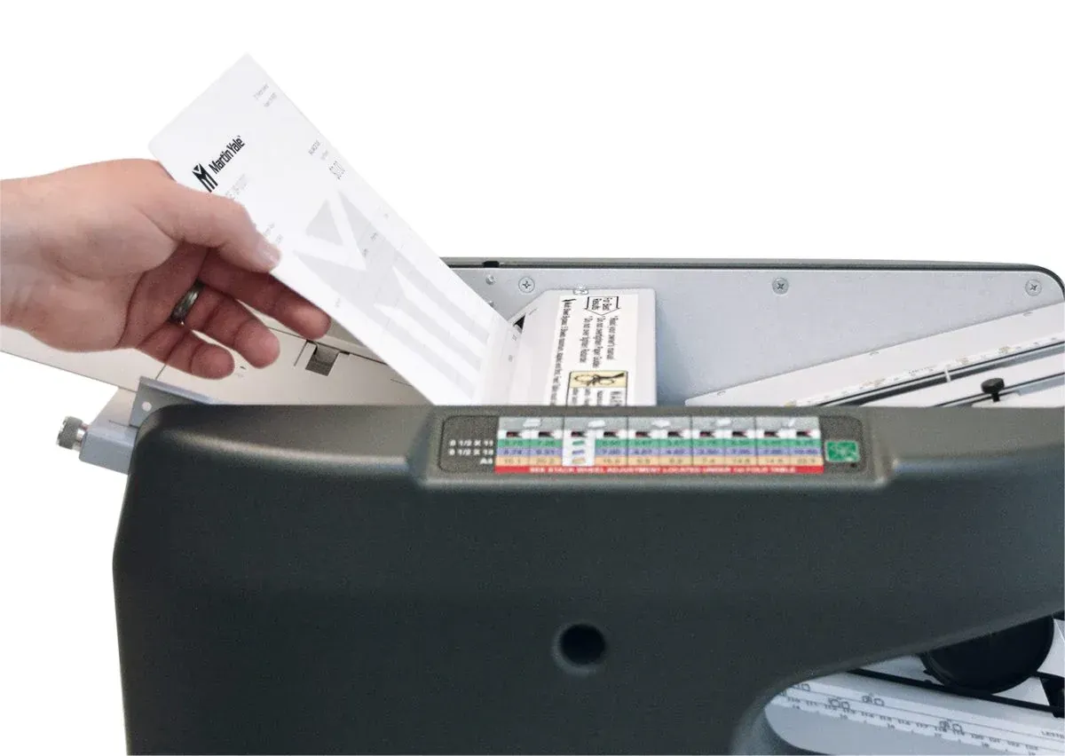 A person is putting a piece of paper into a machine.