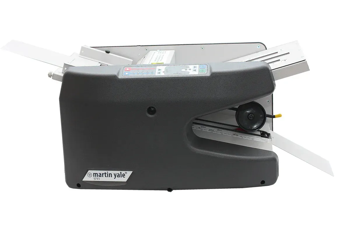 A black envelope maker is sitting on a white surface.