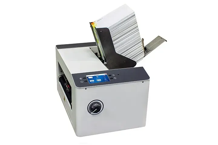 A book is being printed on a machine on a white background.