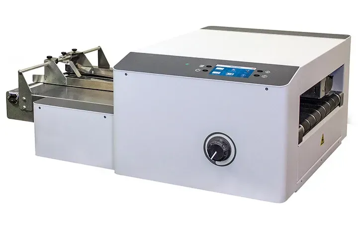 A white machine with a blue screen is sitting on a white surface.