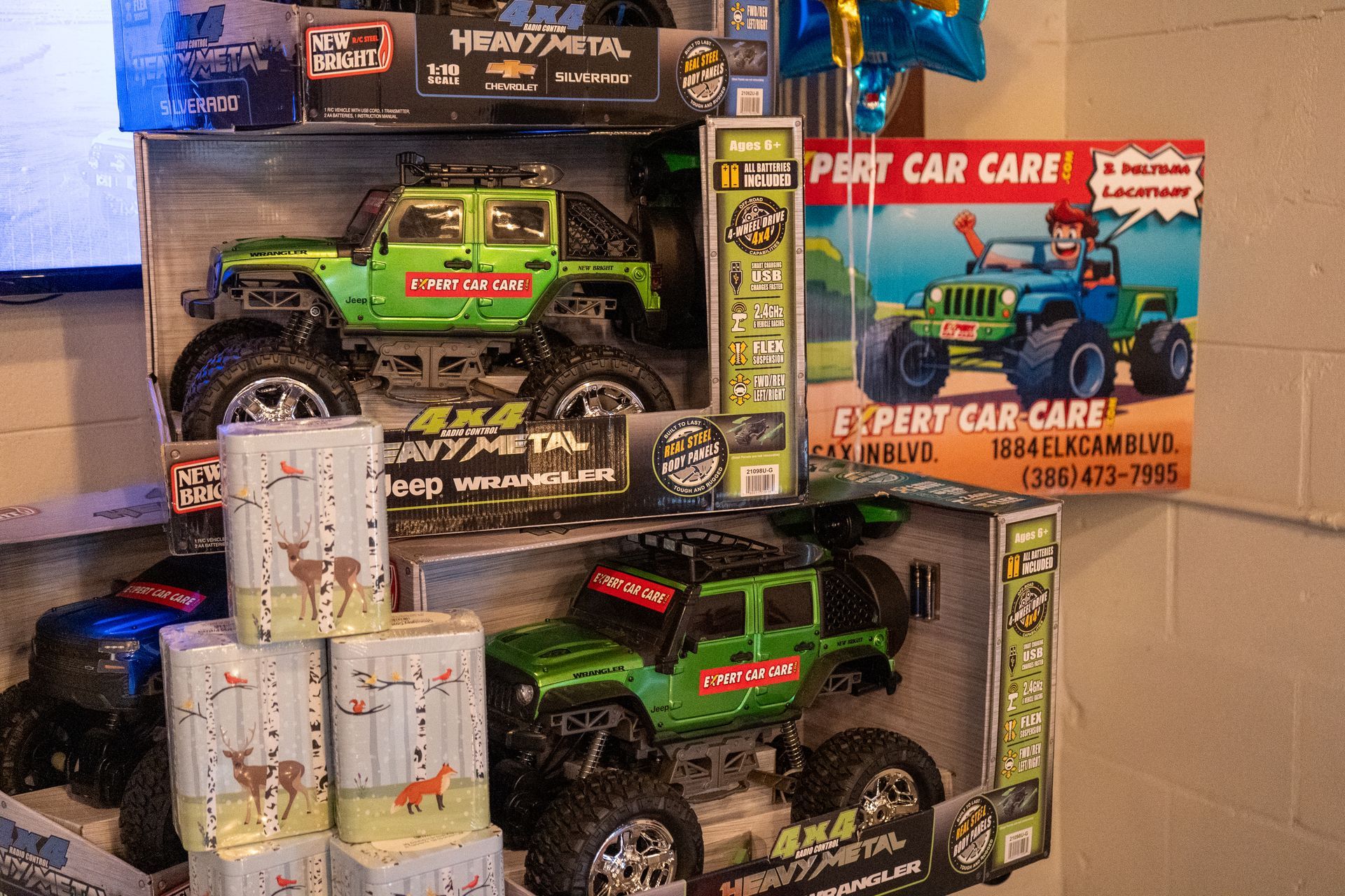 Toy monster trucks and a shark rescue playset stacked in a store display