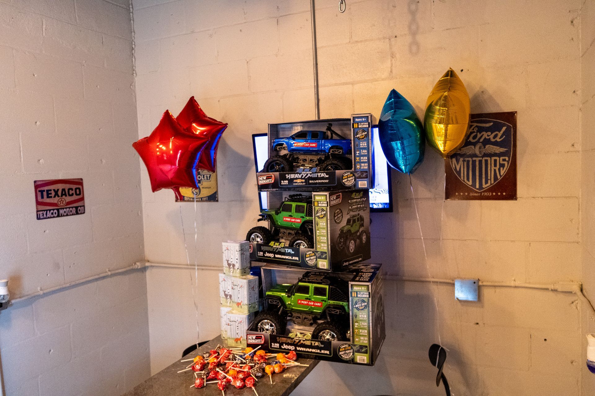 Display of raffle prizes and gift baskets with star balloons against a cinderblock wall