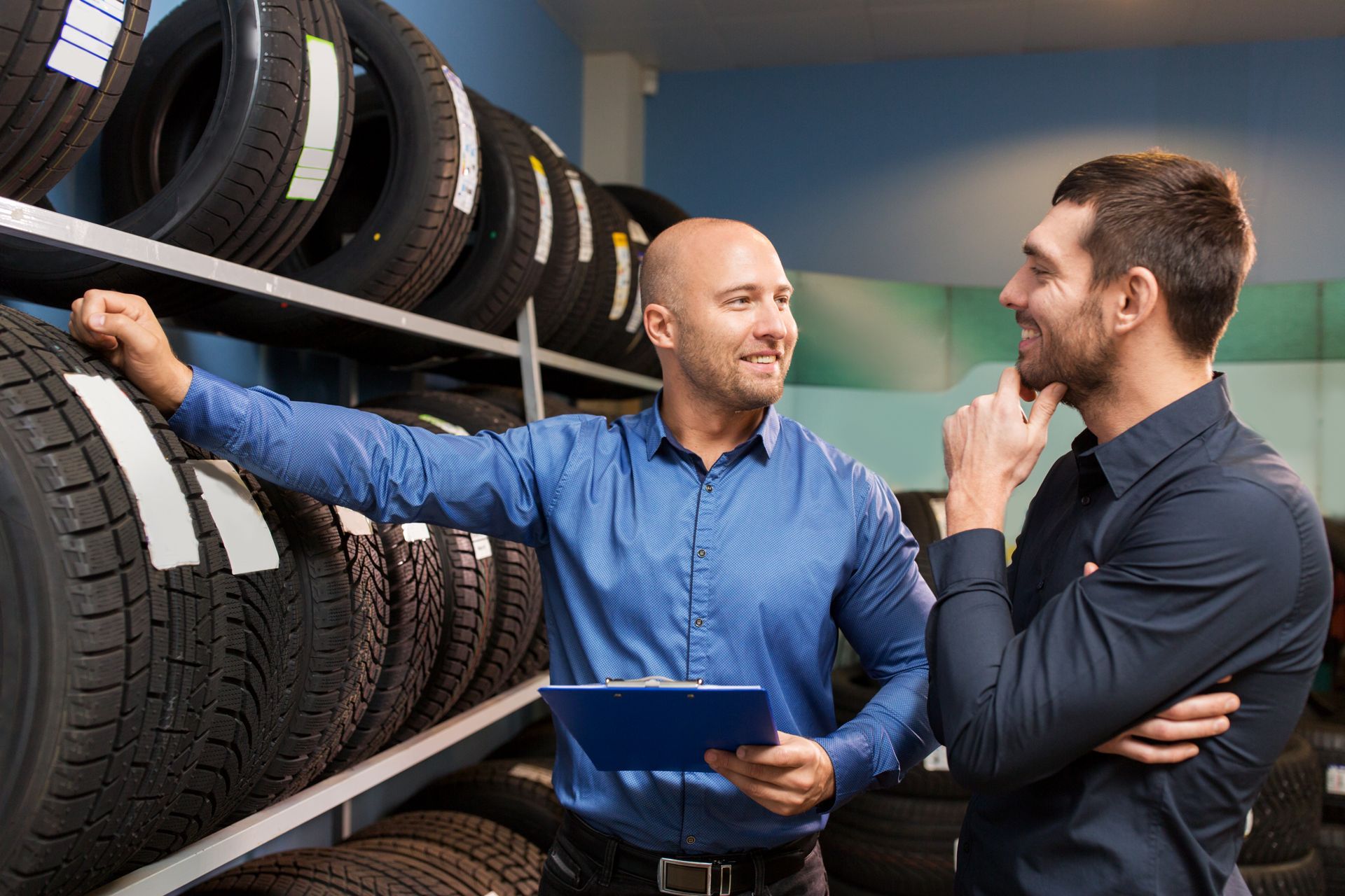 Customer and salesman at car service or tire shop.