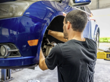 Technician inspecting and servicing brake components on a lifted vehicle during a professional brake service Technician inspecting and servicing brake components on a lifted vehicle during a professional brake service