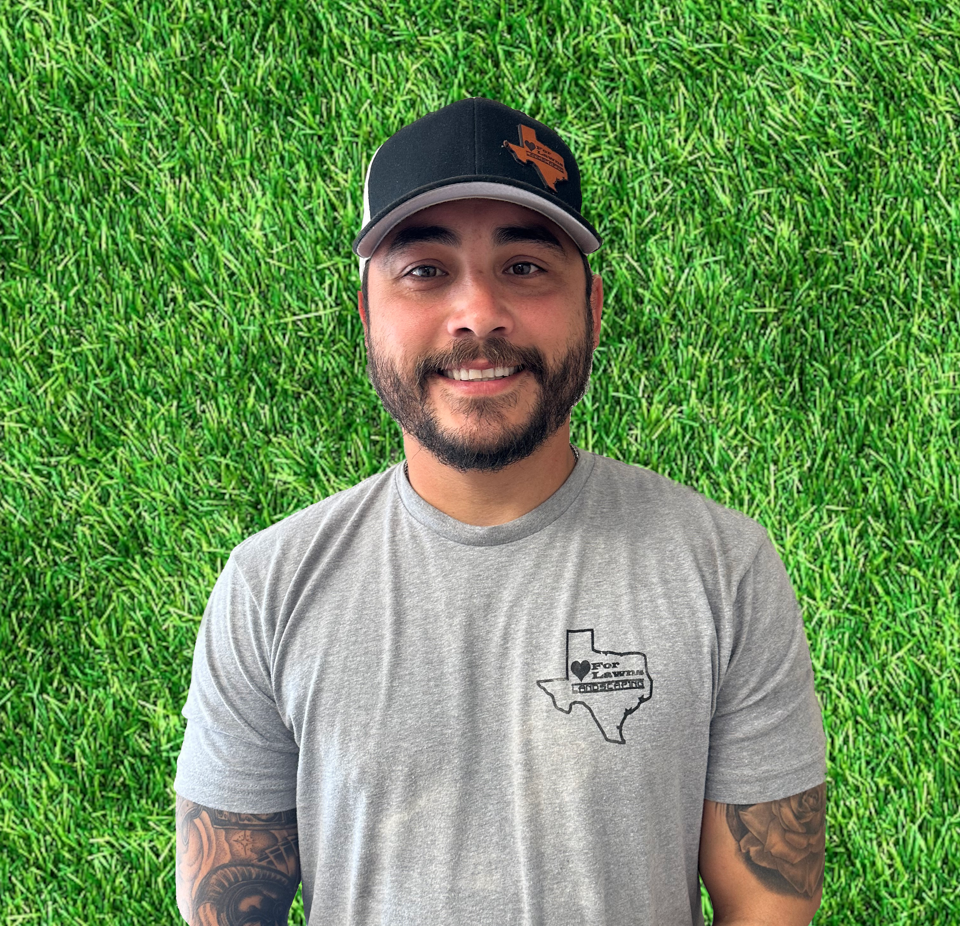 A man with a beard is wearing a hat and a gray shirt.