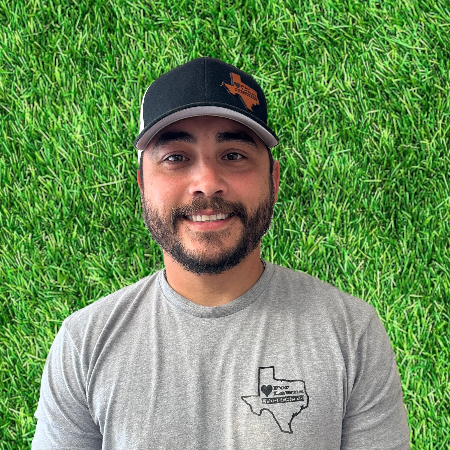 A man with a beard is wearing a hat and a gray shirt.