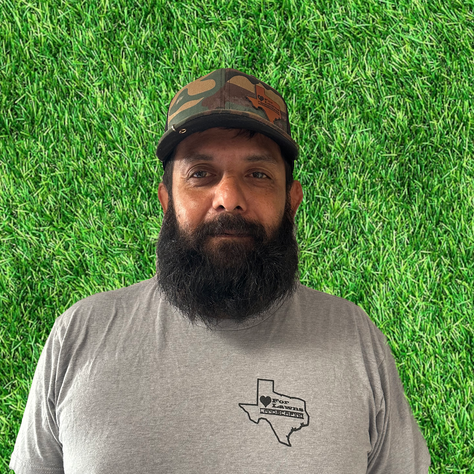 A man with a beard is wearing a hat and a gray shirt.