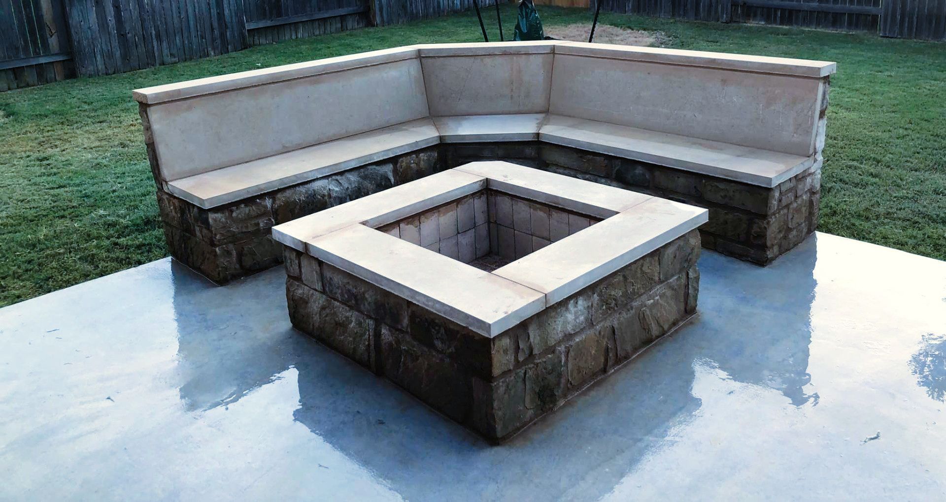 A concrete patio with a fire pit and a couch