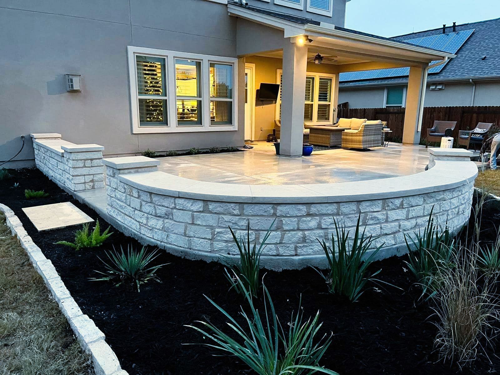 A house with a patio and a brick wall in front of it