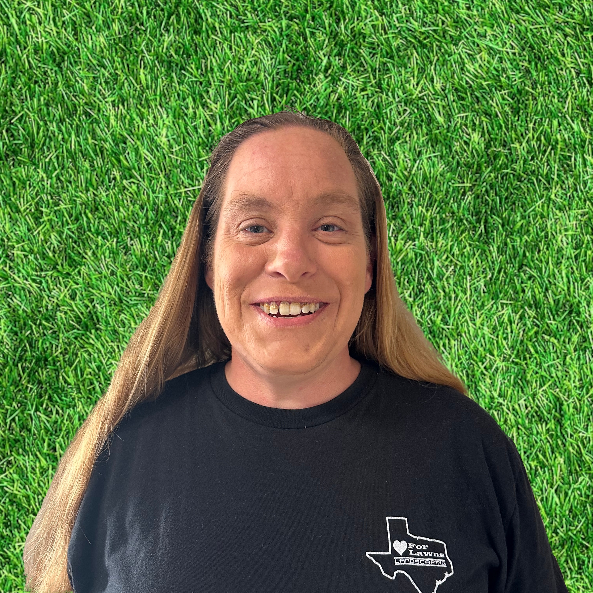 A woman in a black shirt is smiling in front of a green background.