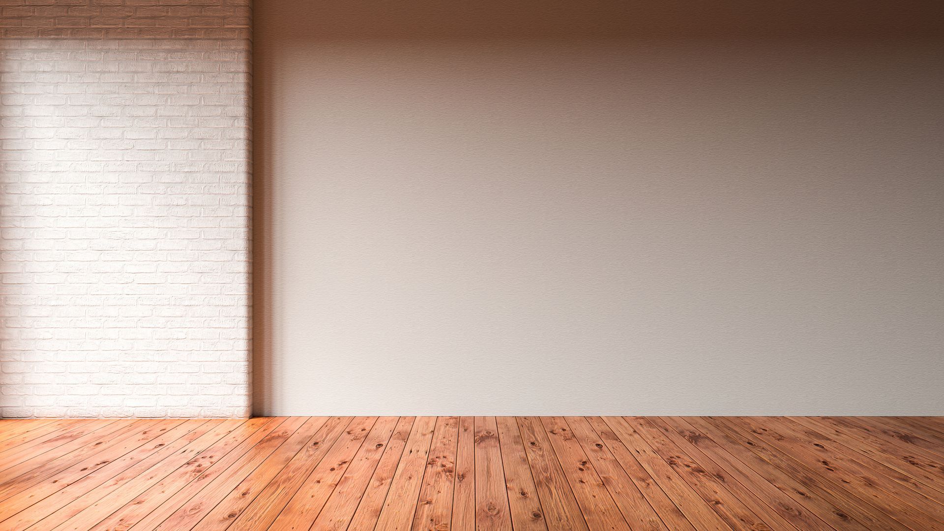 Una stanza vuota con un pavimento in legno e un muro di mattoni bianchi.