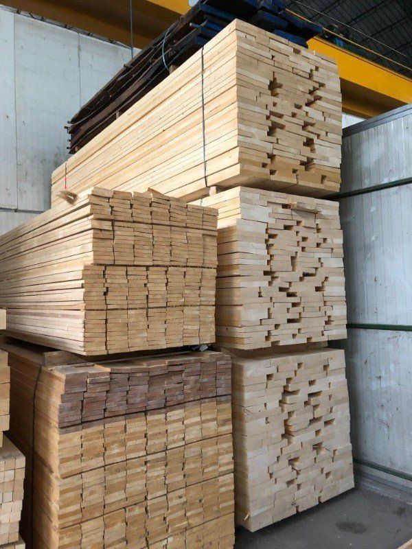 Un magazzino pieno di assi di legno accatastate l'una sull'altra.