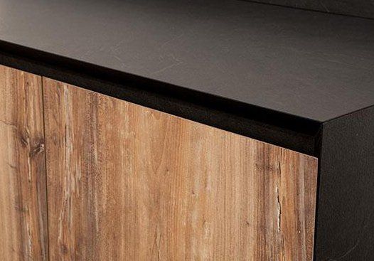 Primo piano di un mobile in legno con un piano di lavoro nero.