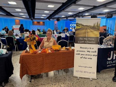 Woman at table with fall decorations at an event; banner reads