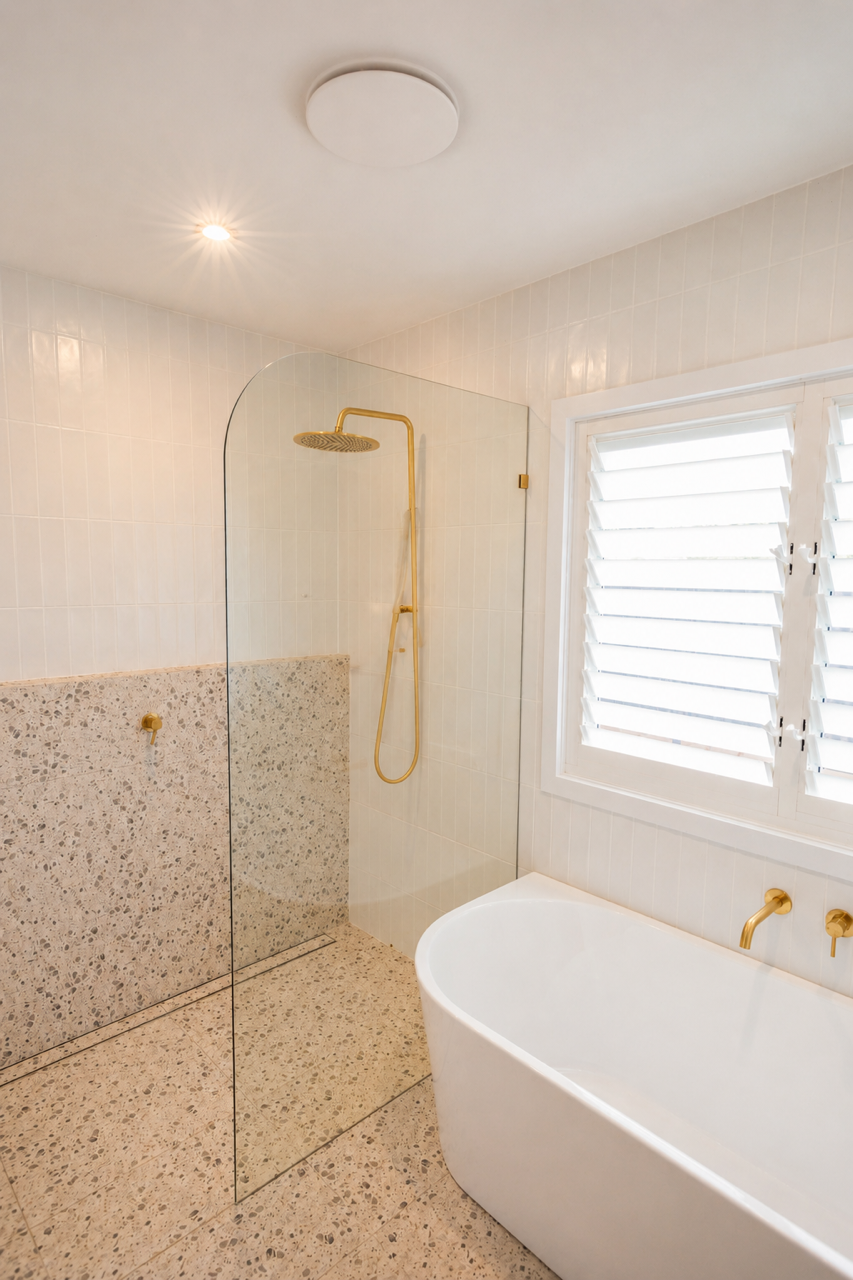 Modern bathroom with glass shower enclosure, tiled walls, and a white sink in the foreground