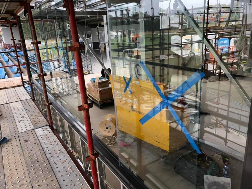 Construction site with glass wall marked by blue tape in a modern building interior