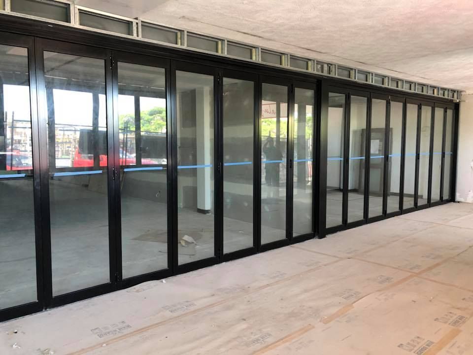 Black-framed glass storefront doors in an empty indoor mall corridor
