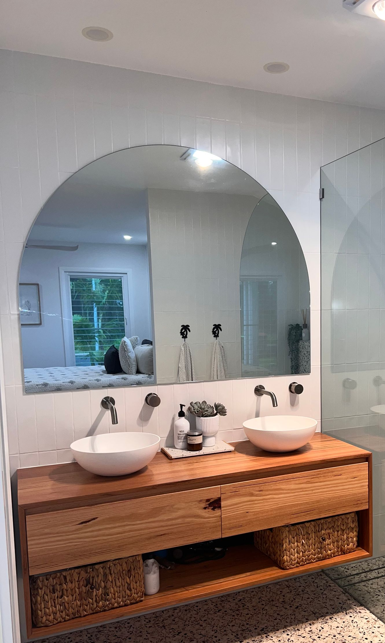 Bathroom mirror above sink with pendant light and hallway reflected in the glass