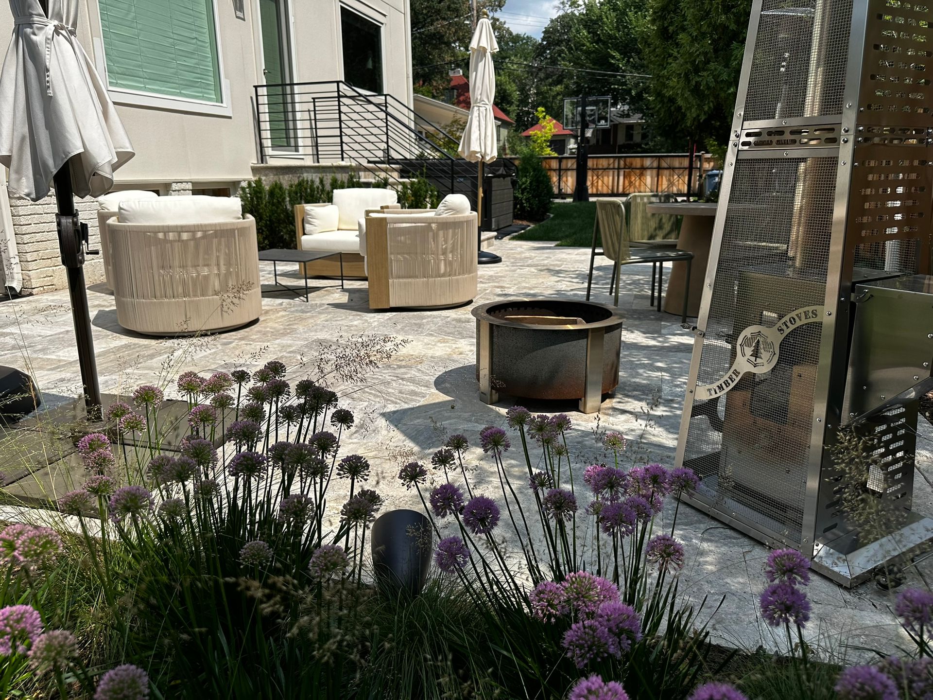 Outdoor living patio space in Minneapolis backyard with stone faced steps and modern railing natural stone pavers new fence plantings cozy seating 