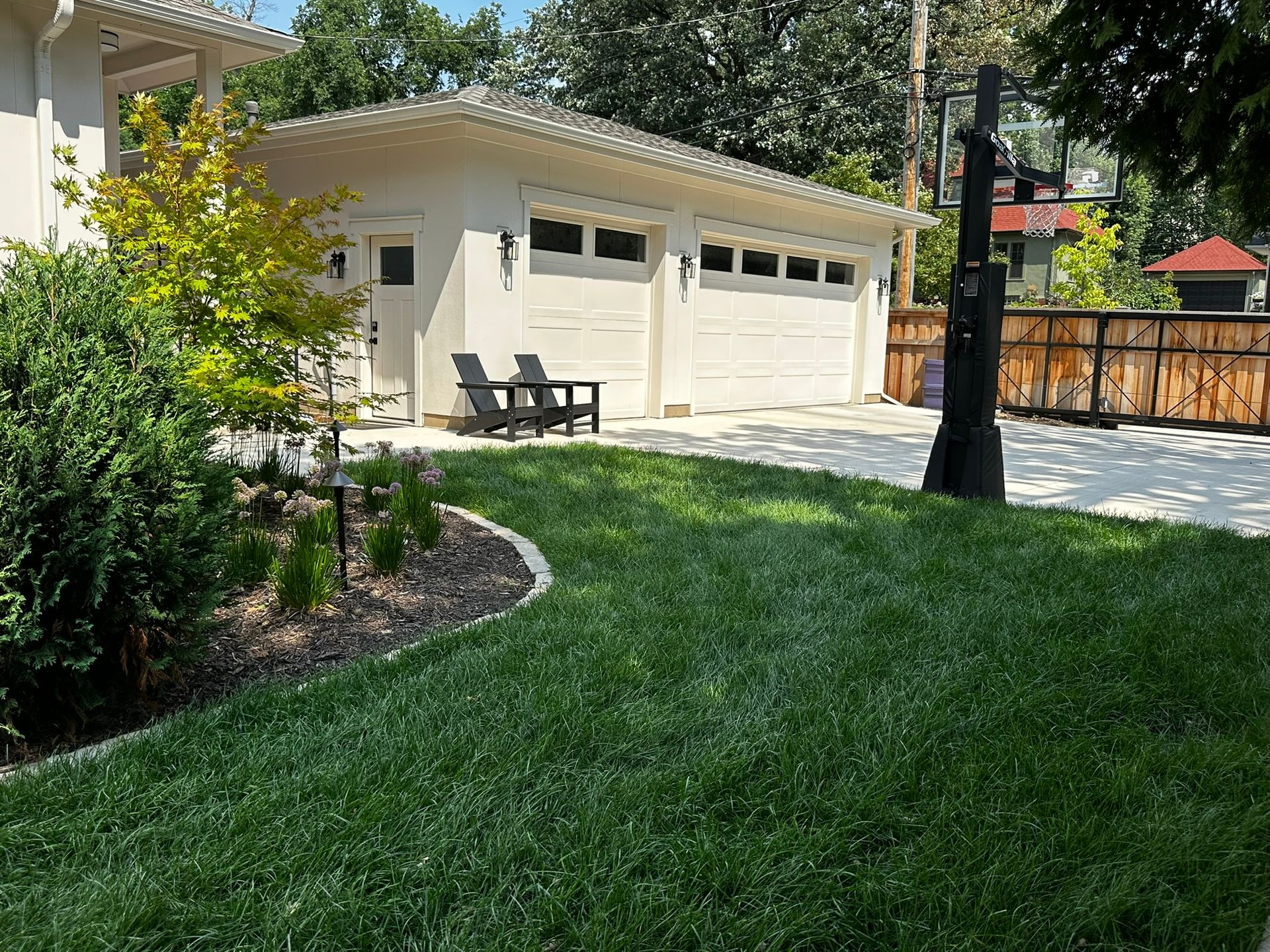 After: new garage and cement driveway, KG installed new basketball hoop hardscape, landscaping and Fencing shown in this picture in Minneapolis 
