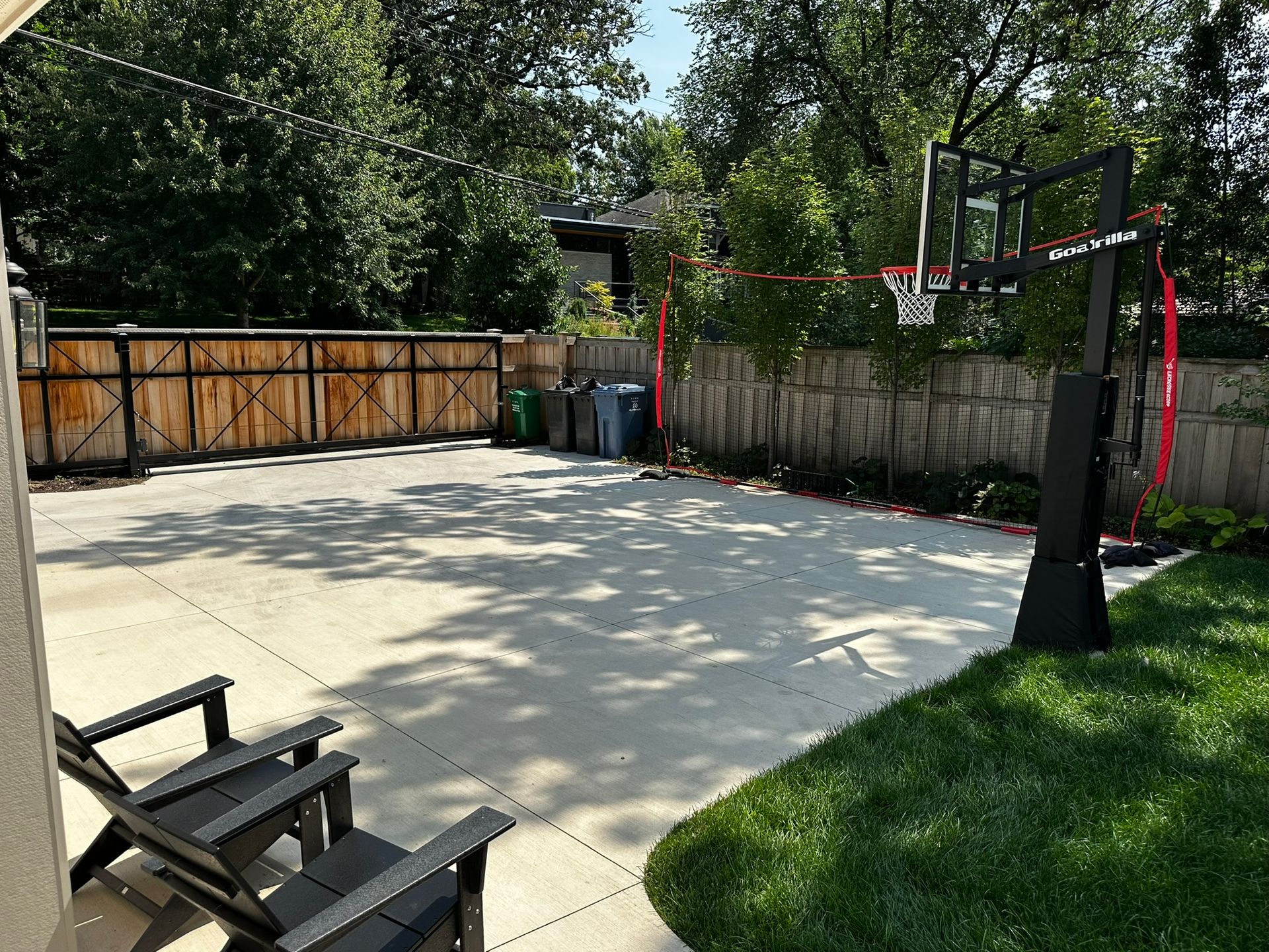 After: new cement driveway with screen plantings, new cedar fence with automatic driveway gate for security and privacy in Minneapolis  