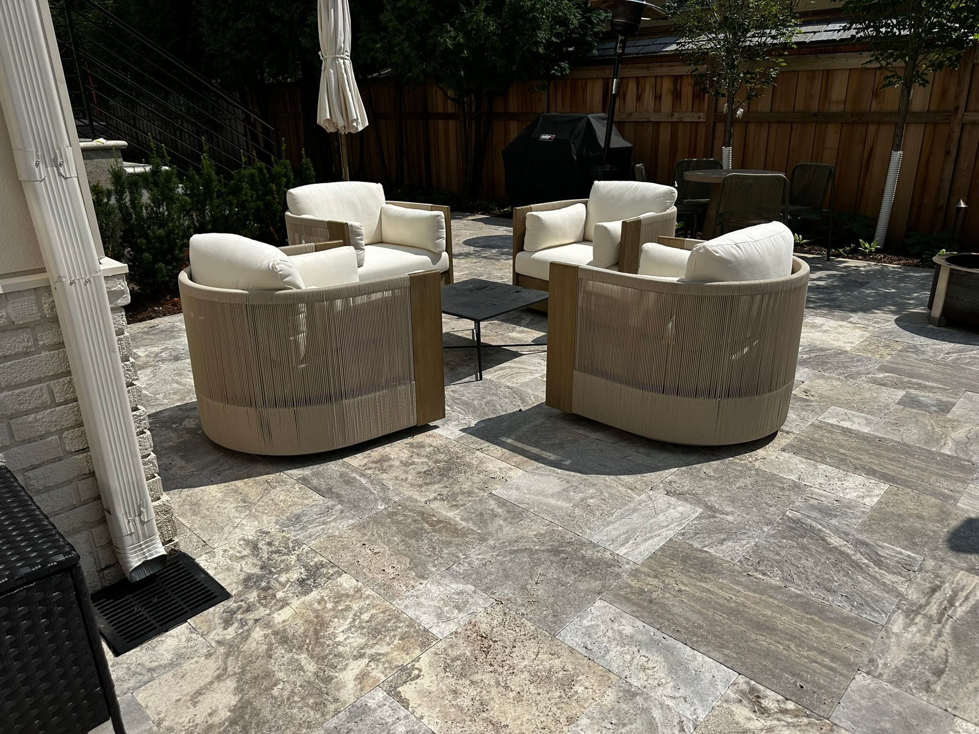 After: new backyard patio space with underground downspout catch basin and pipe to send gutter water safely below patio in Minneapolis 