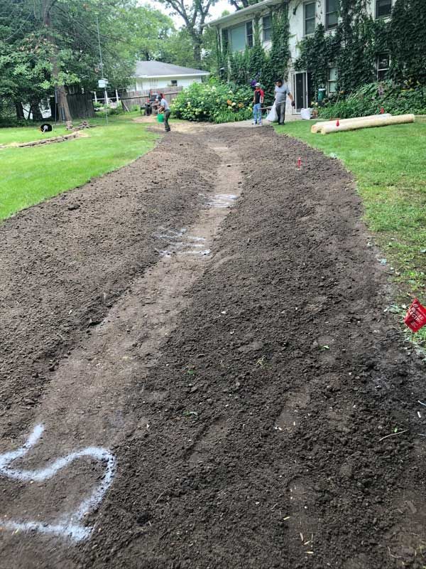 A house is surrounded by trees and rocks in a garden.