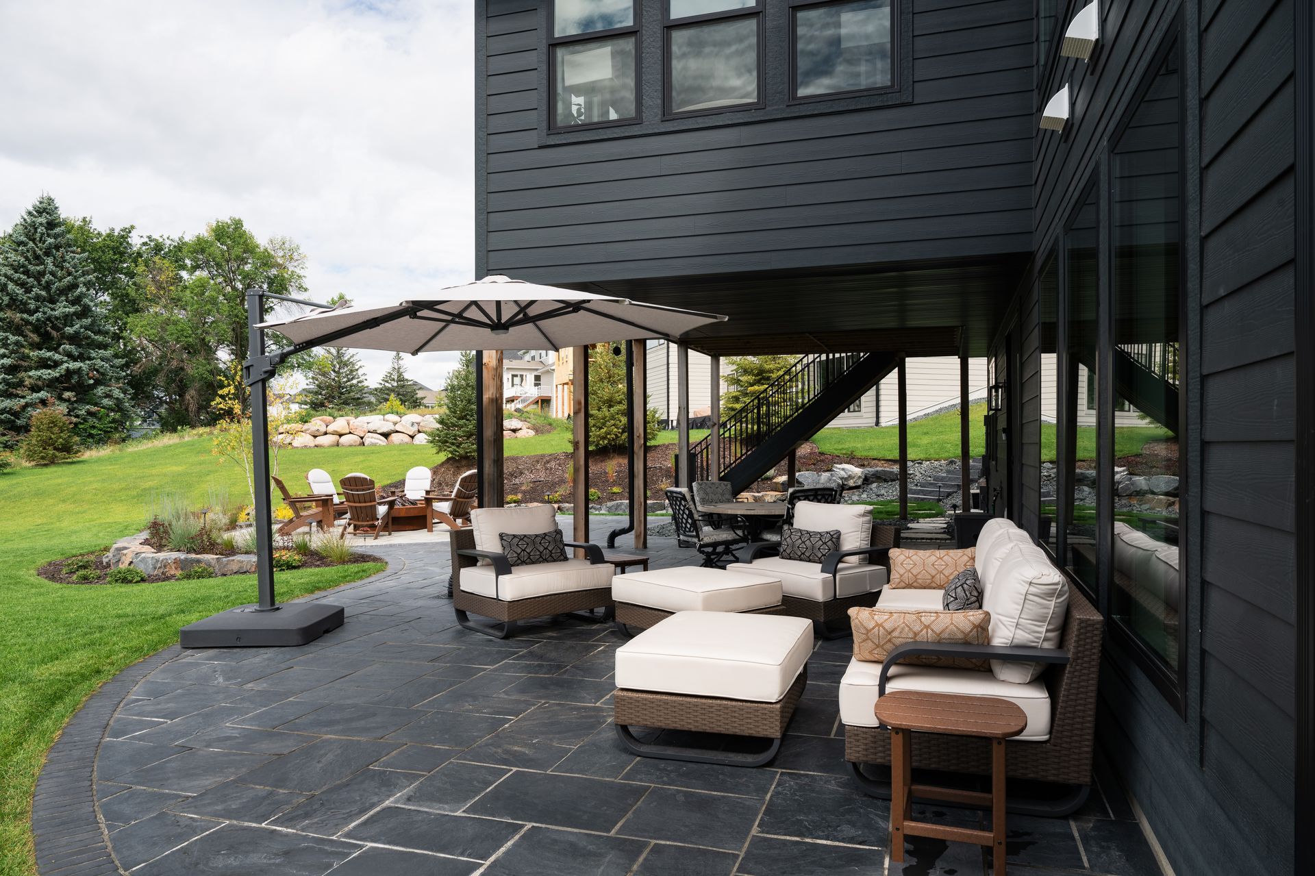 High end patio with black cut and patterned flagstone and nice furniture for walkout basement home in Plymouth MN