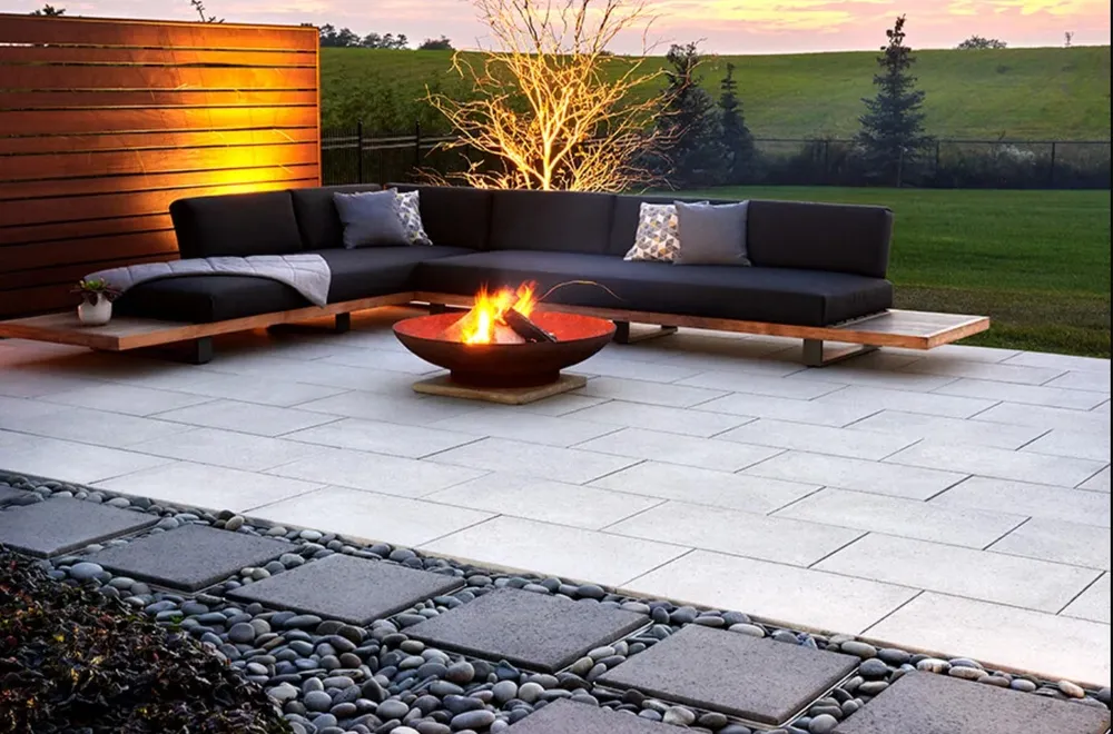 A patio with a fire pit and a sectional couch