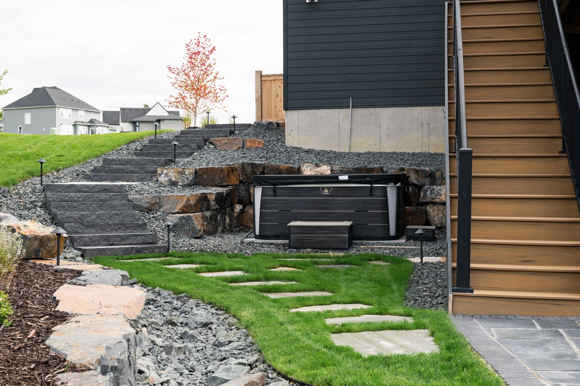 Landscape steps with flagstone stepping stone pathway in lawn connecting outdoor stairs with hot tub area and deck steps in Plymouth MN design by KG Landscape