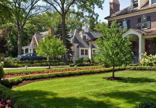 A grill is sitting on a patio next to a brick wall.