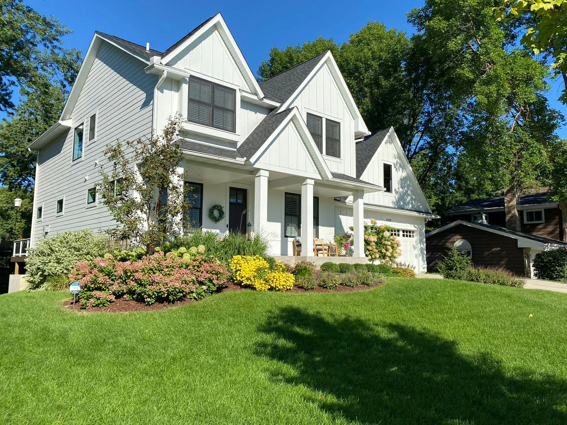 Front yard landscaping for a new-build home with seasonal color, grasses, and evergreens in Edina MN