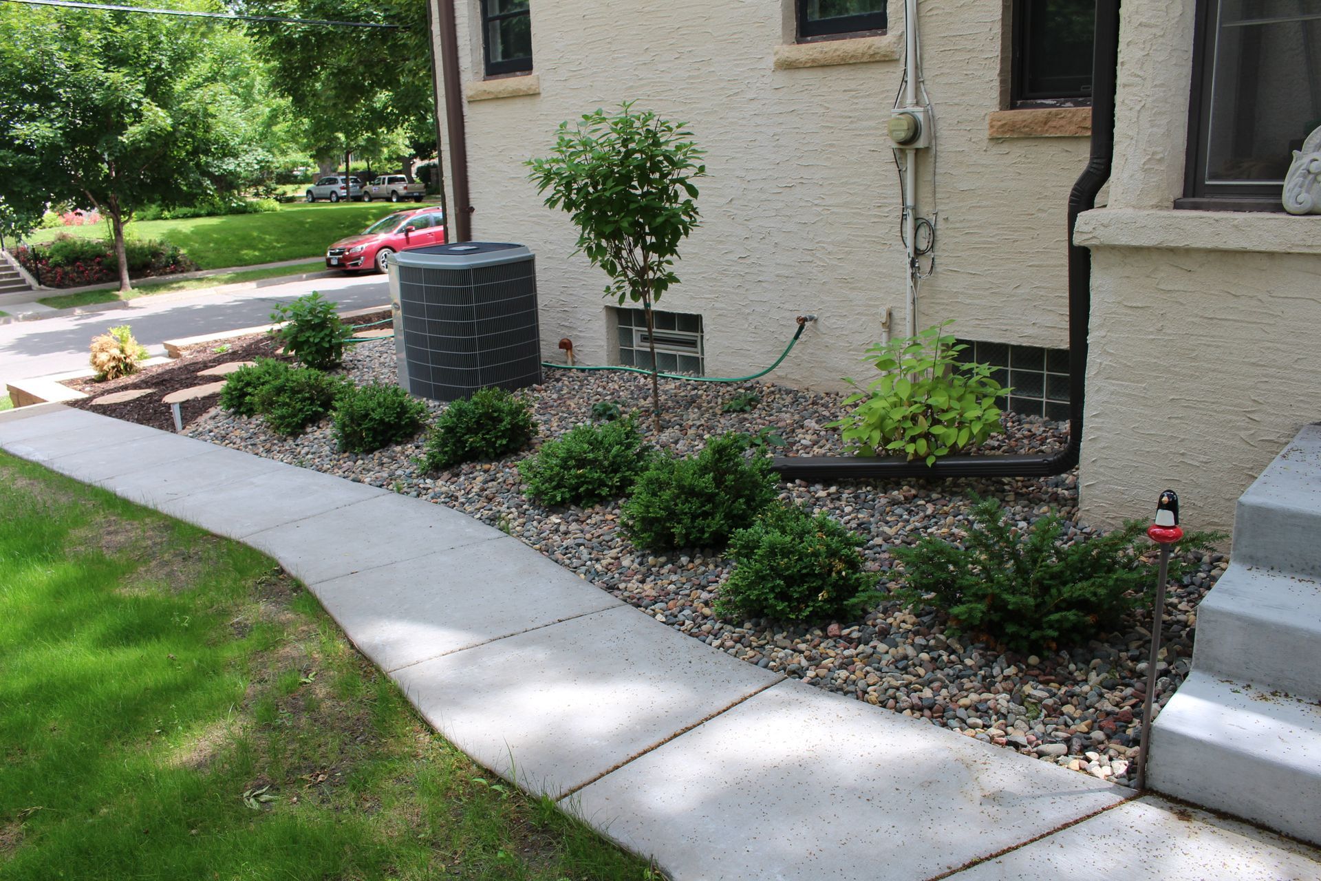 Regraded foundation area with rock and plantings a year after drainage work near Lake of the Isles