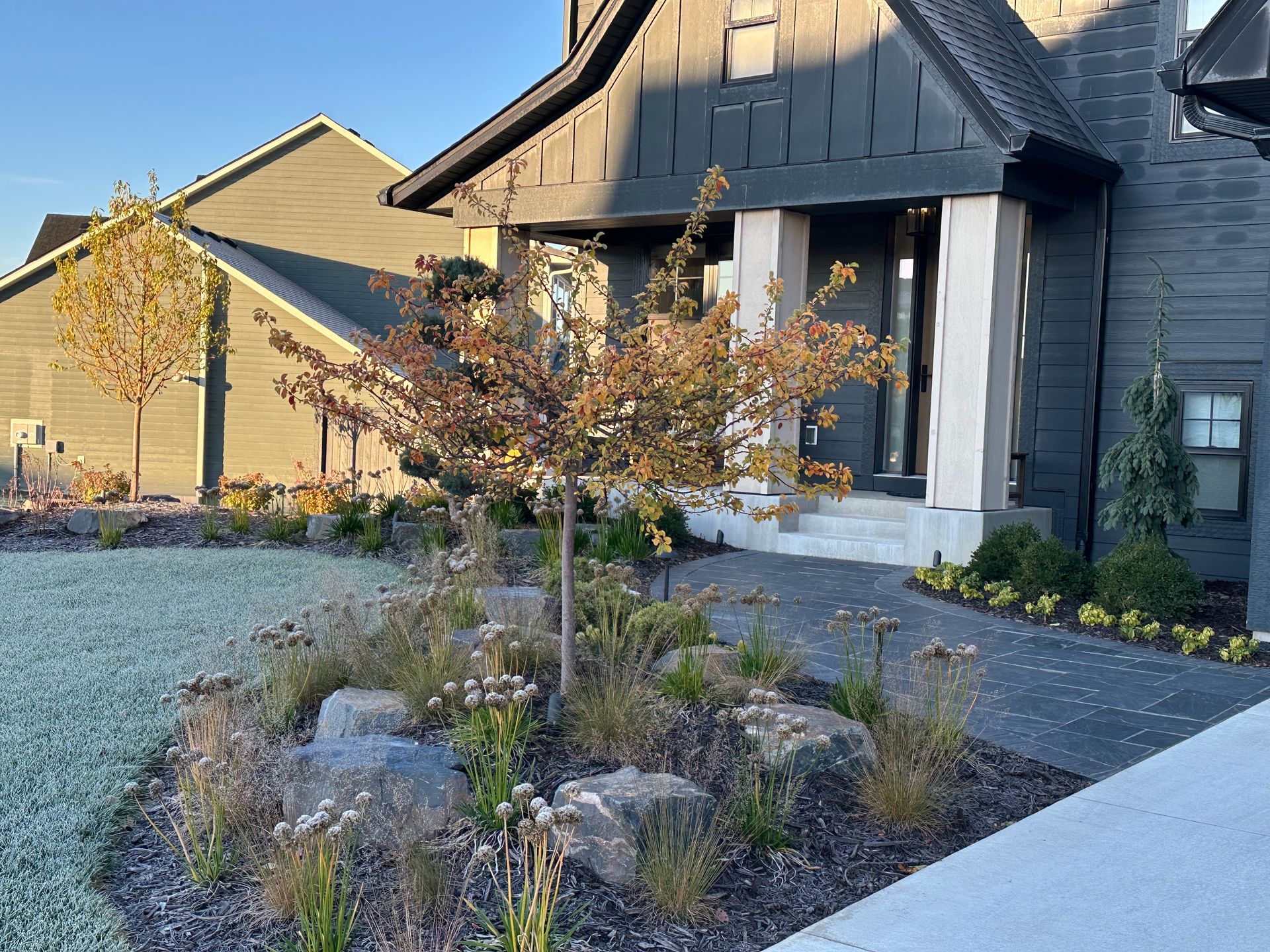 Front yard with trap boulder outcroppings and mounded beds we did in Plymouth MN project by KG Landscape 