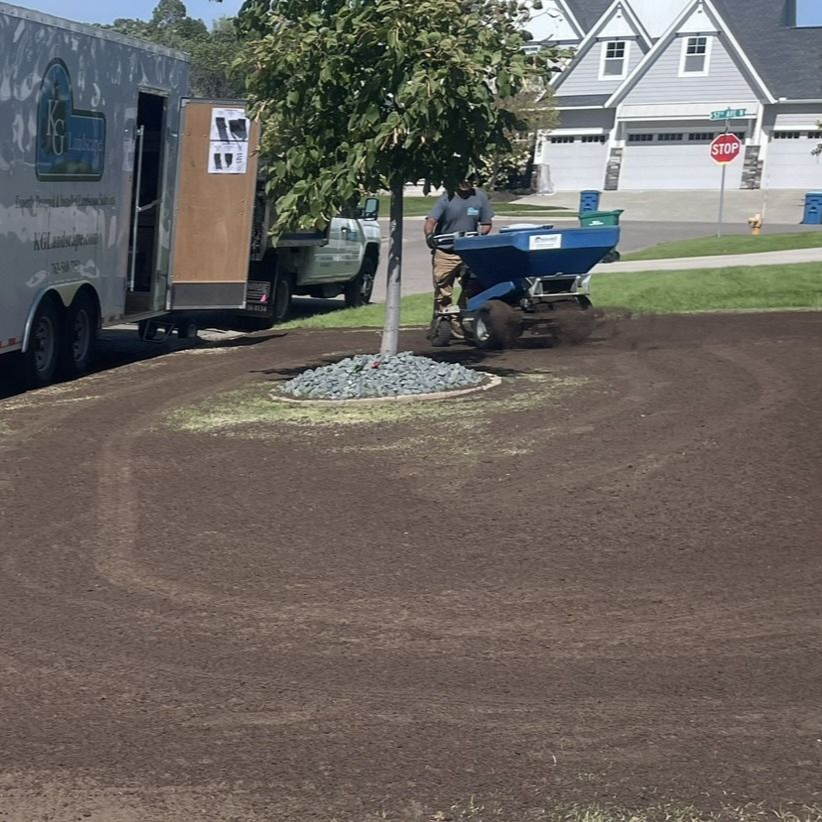 crew topdressing a lawn in MN with topsoil and top dresser machine