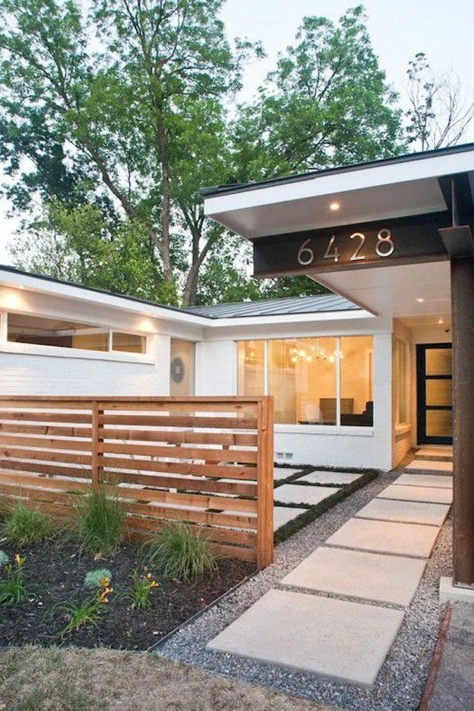 Modern white house with wooden fence, walkway, and address numbers 6428.