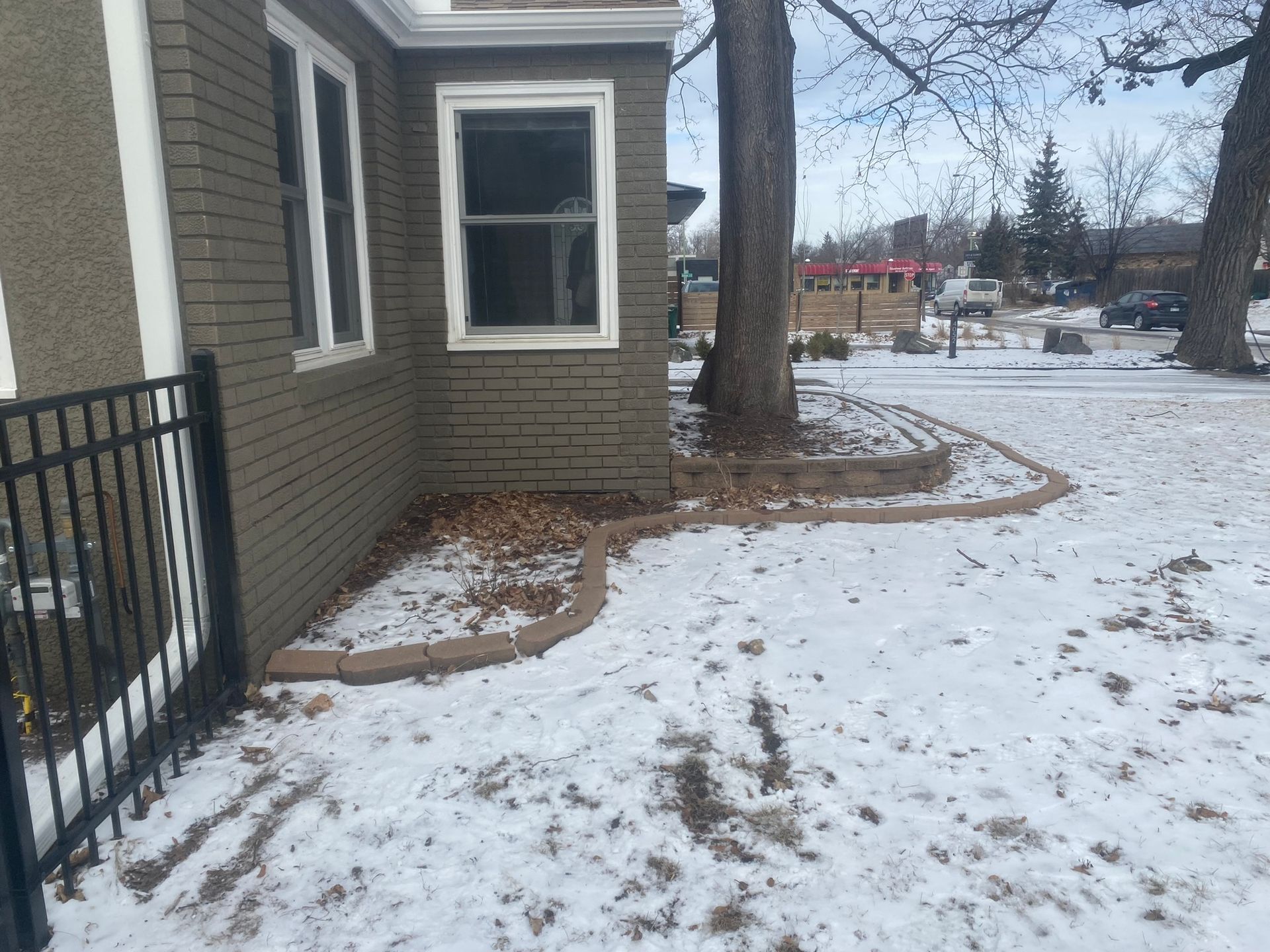 A picture of a curved retaining wall that is beginning to lose its structural integrity.