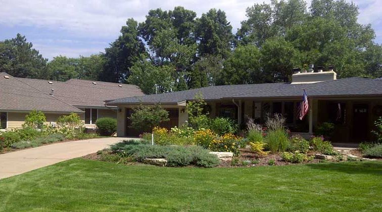 Front yard with large beds and gray-white limestone boulder outcroppings in Edina MN