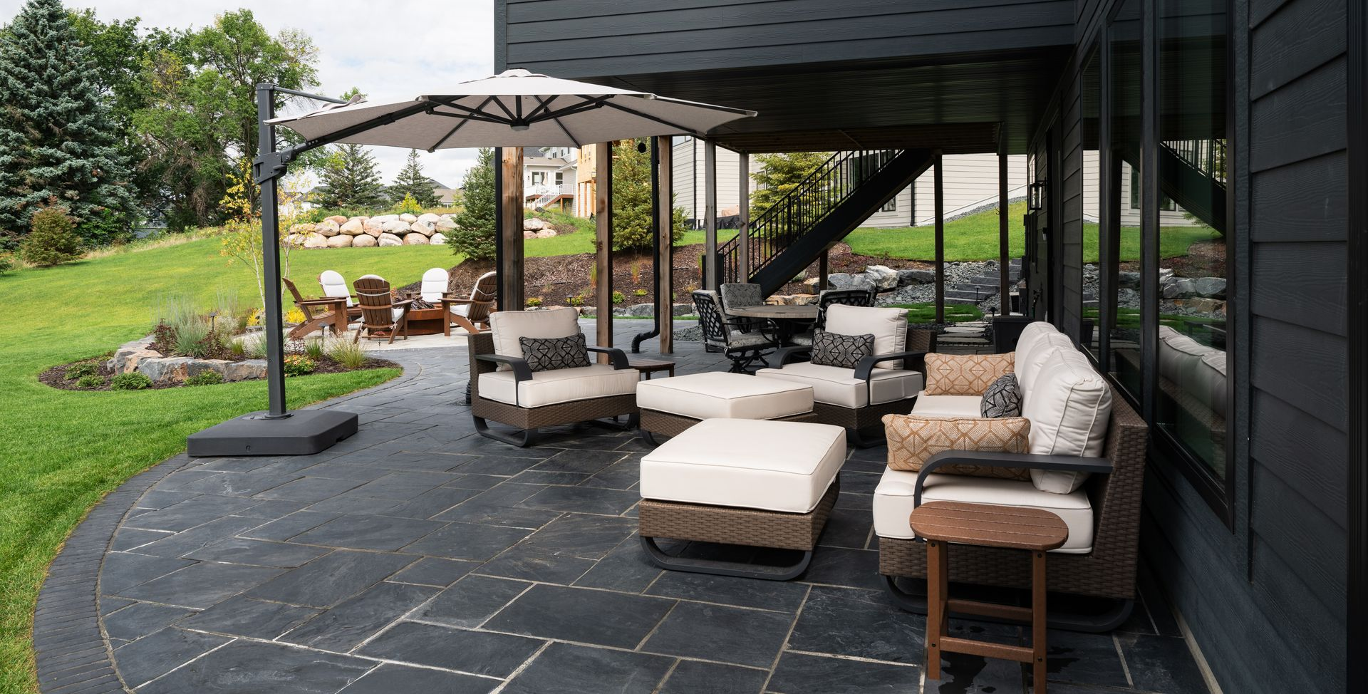 Backyard patio for a walkout-basement home in Minnetrista MN with fire pit and lounge areas