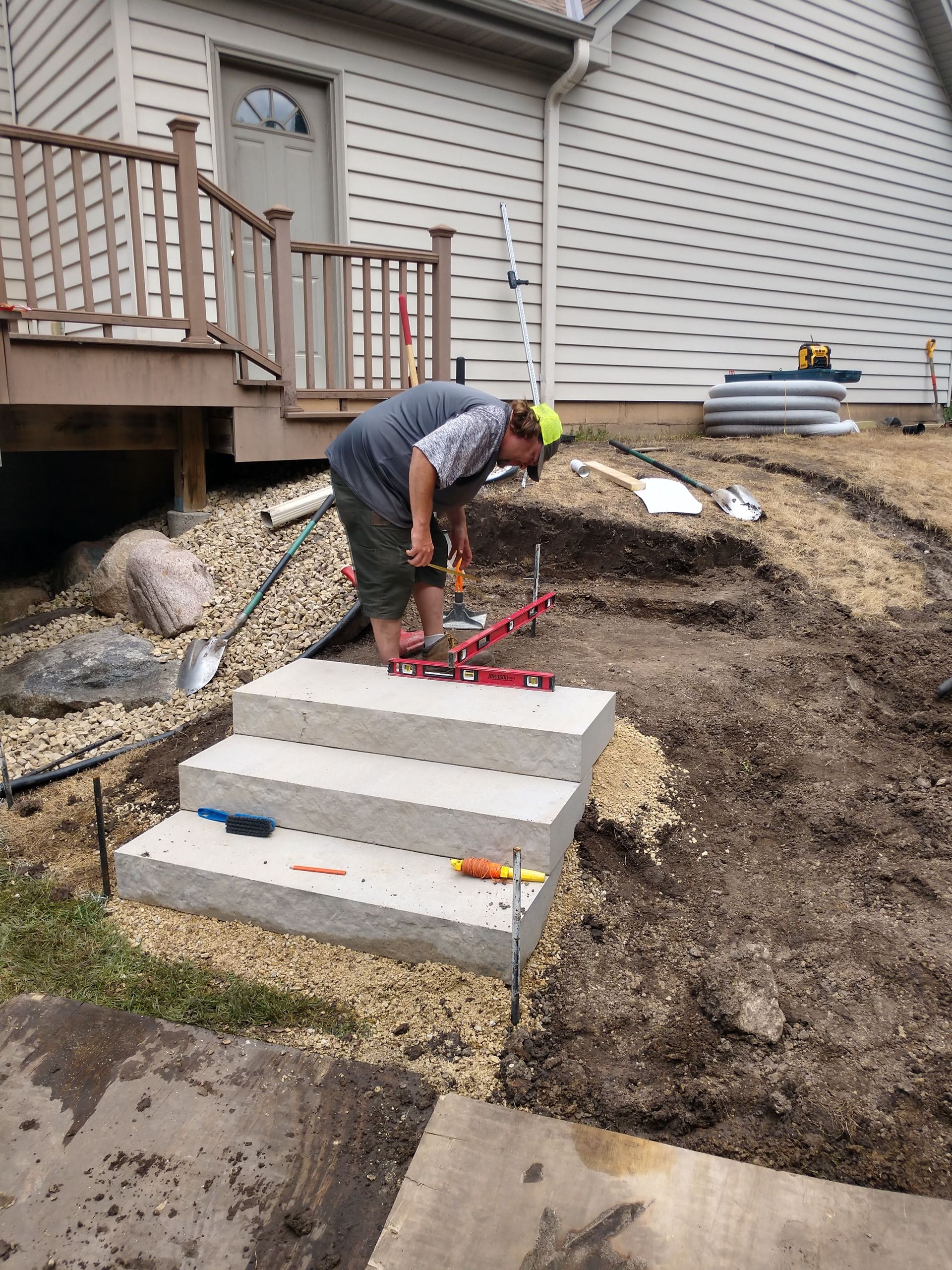 New Hillside steps being installed and level by crew with boulder wall 