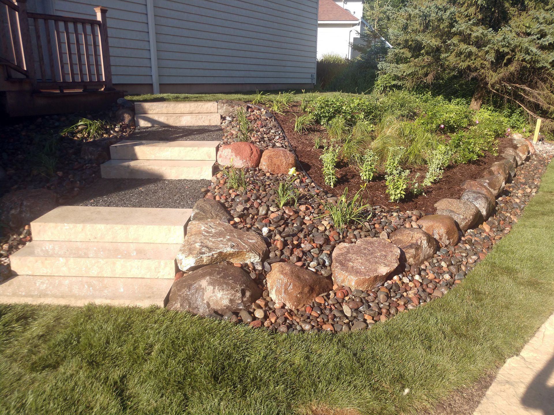 After - completed hillside landscaping on steep slope with steps and plantings