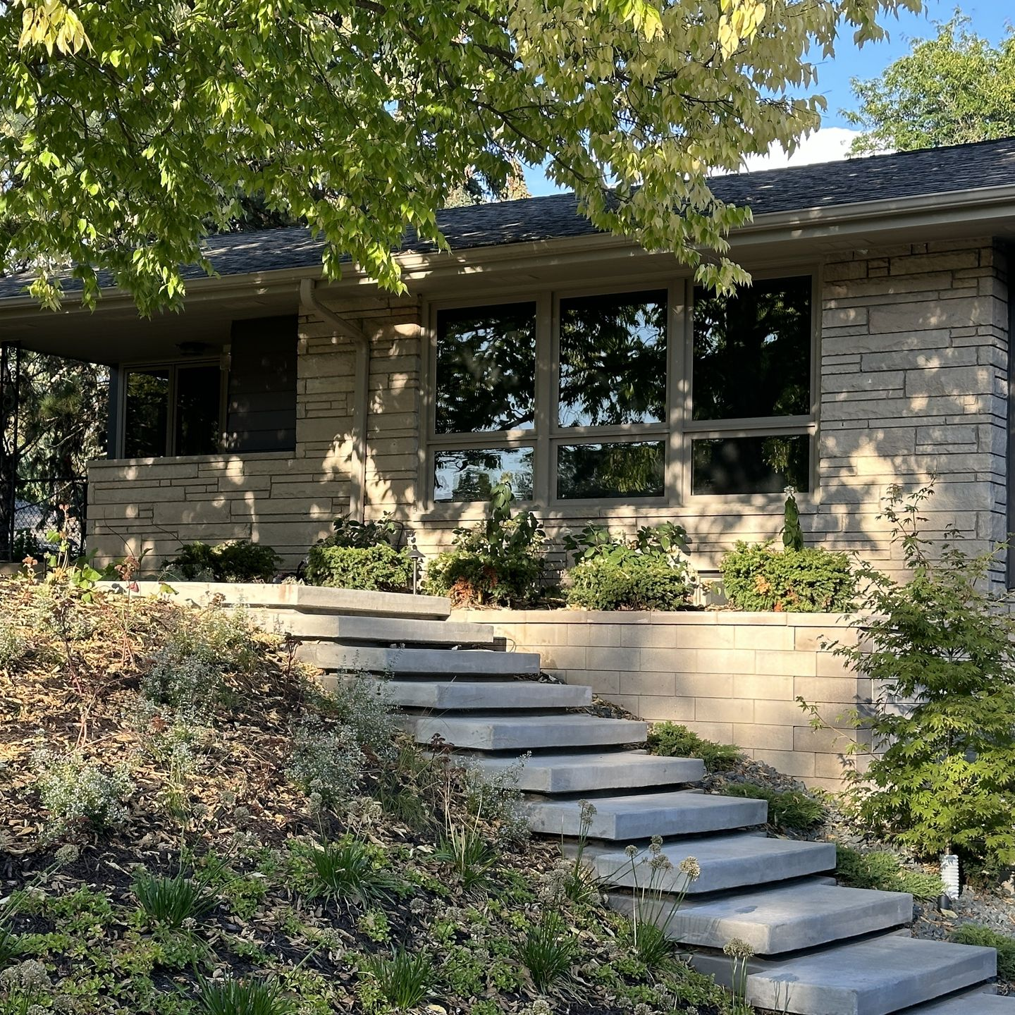 Custom floating concrete steps, retaining wall and front entry plantings design project by KG Landscape in Golden Valley MN